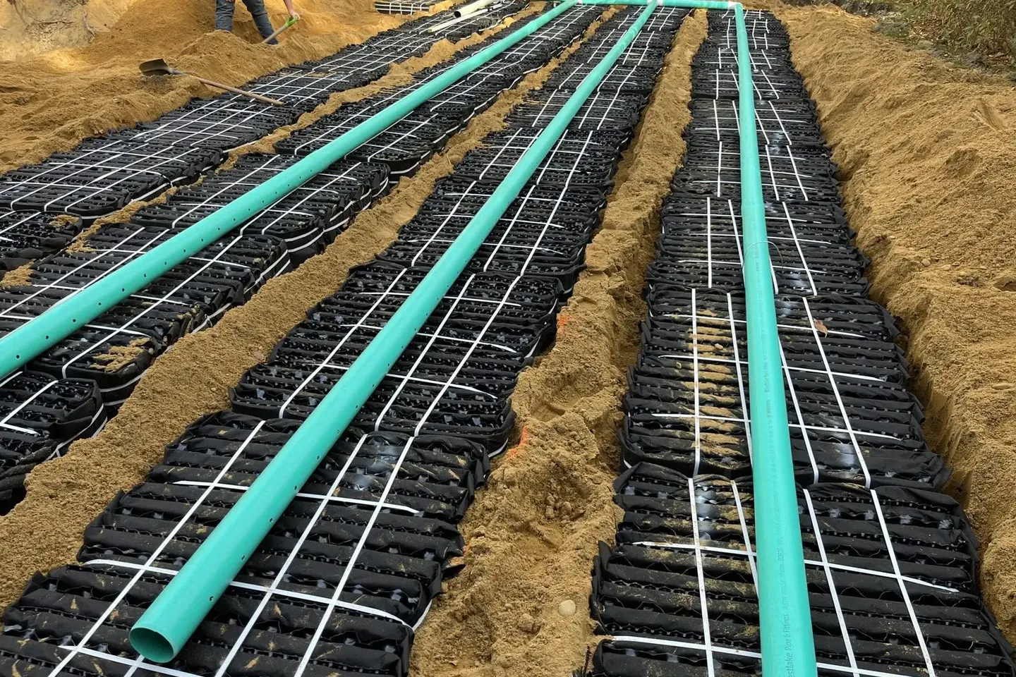 Septic leach field pipes and chambers set in sand before backfill on a Riverview septic installation