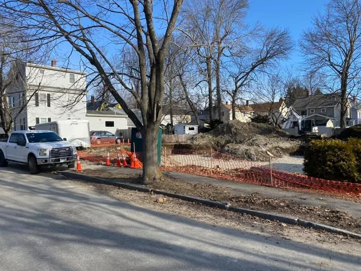 Roadside work area closed off with fencing and cones