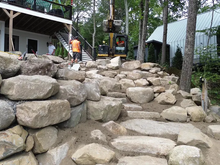 Drone view of boulder steps leading up a hillside toward a house