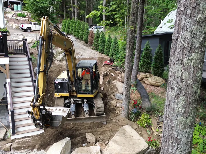 Mini excavator working at the bottom of a deck stairway