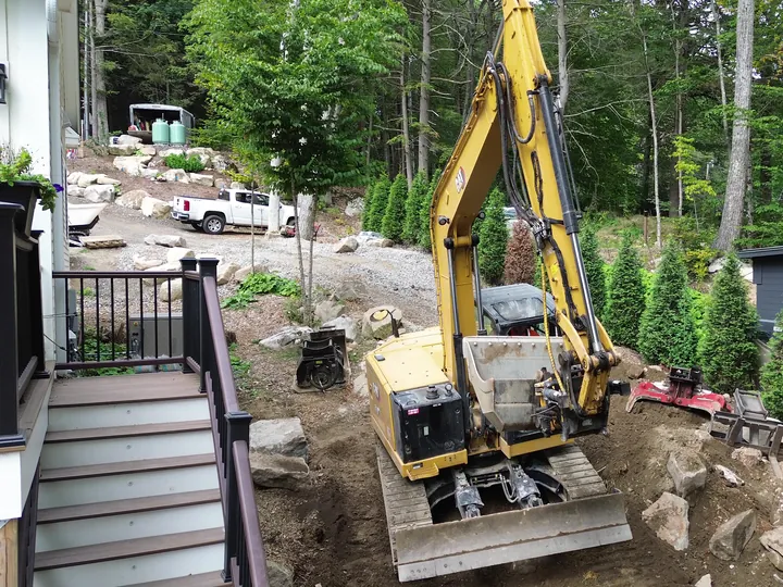 Drone view of an excavator on a slope next to a deck stairway