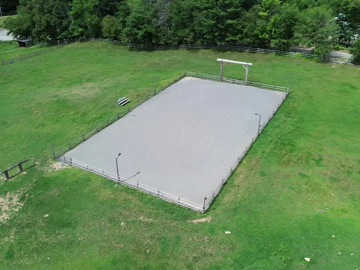 Drone view of a level gravel pad in an open grassy field