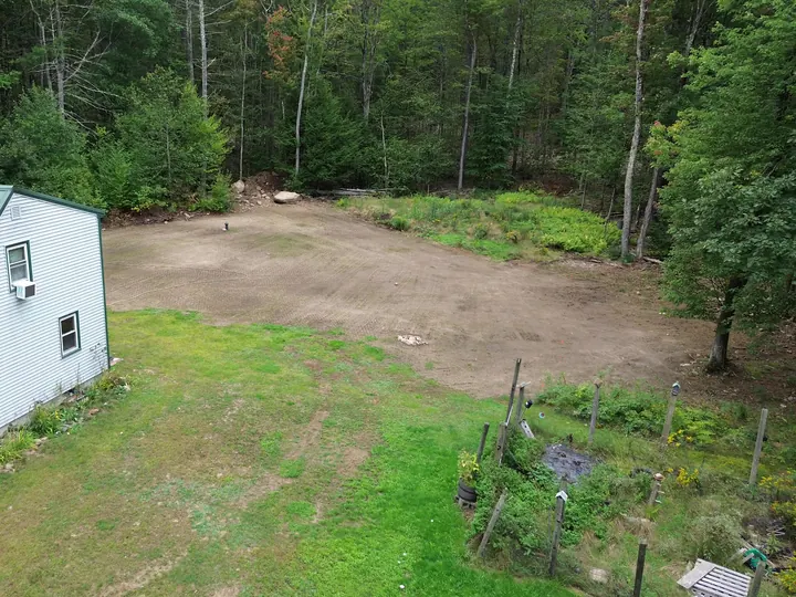 Drone view of a big yard leveled out to the woods