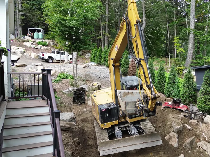 Mini excavator digging in a tight spot near a house