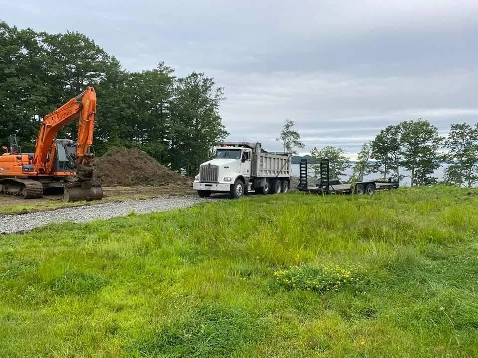 Excavator and dump truck on an open lot on the first day of digging